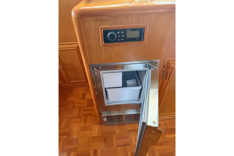 The Dude Yacht Photos Pics 1995 Ocean Alexander 486 yacht interior with open stainless steel refrigerator and wooden cabinetry.