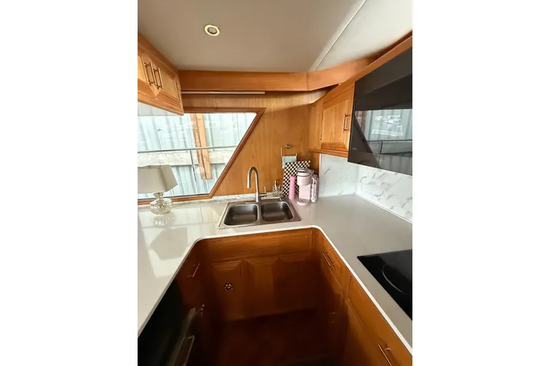 The Dude Yacht Photos Pics Luxurious kitchen interior of 1995 Ocean Alexander 486 yacht with wooden cabinetry and modern fixtures.