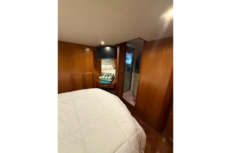 The Dude Yacht Photos Pics Cozy bedroom in 1995 Ocean Alexander 486 yacht with wood paneling and modern amenities.