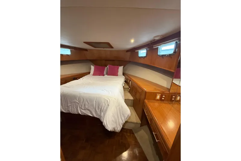 The Dude Yacht Photos Pics Luxurious 1995 Ocean Alexander 486 yacht bedroom with wood accents and cozy bedding.