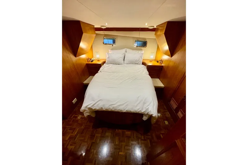 The Dude Yacht Photos Pics Cozy bedroom interior on 1995 Ocean Alexander 486 yacht with wood accents and soft lighting.