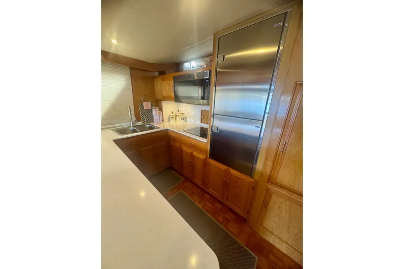 The Dude Yacht Photos Pics 1995 Ocean Alexander 486 yacht kitchen with stainless steel appliances and wooden cabinetry.