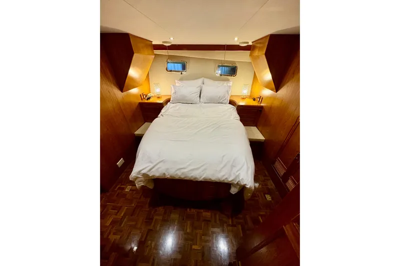 The Dude Yacht Photos Pics Cozy bedroom in 1995 Ocean Alexander 486 yacht with wood paneling and ambient lighting.