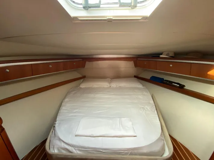  Yacht Photos Pics Cozy cabin interior of 2006 Tiara Yachts 42 with a skylight and wooden accents.