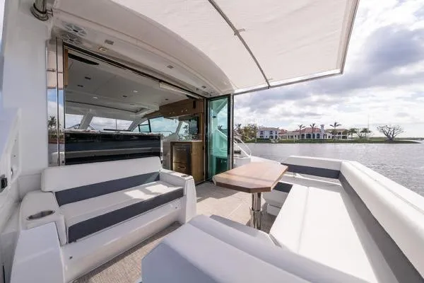  Yacht Photos Pics 2018 Cruisers Yachts 50 Cantius luxury deck with seating, table, and waterfront view.