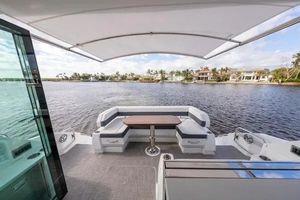  Yacht Photos Pics 2018 Cruisers Yachts 50 Cantius aft deck with seating, table, and waterfront view.