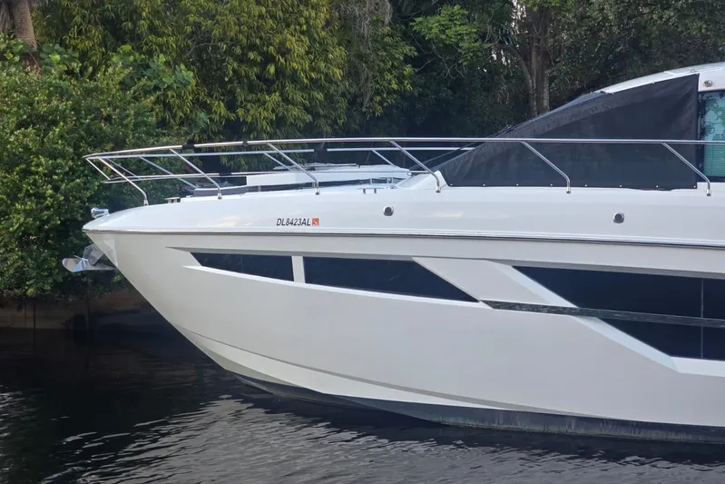  Yacht Photos Pics 2018 Cruisers Yachts 50 Cantius docked near lush greenery.