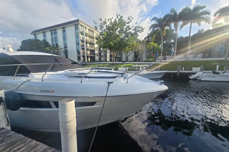  Yacht Photos Pics 2018 Cruisers Yachts 50 Cantius docked by waterfront with palm trees and buildings.