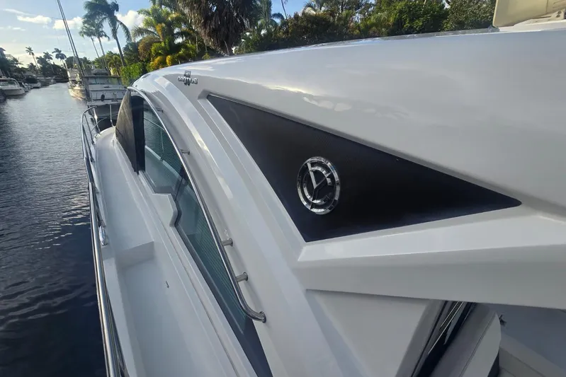  Yacht Photos Pics 2018 Cruisers Yachts 50 Cantius, sleek design, docked by palm-lined waterway.