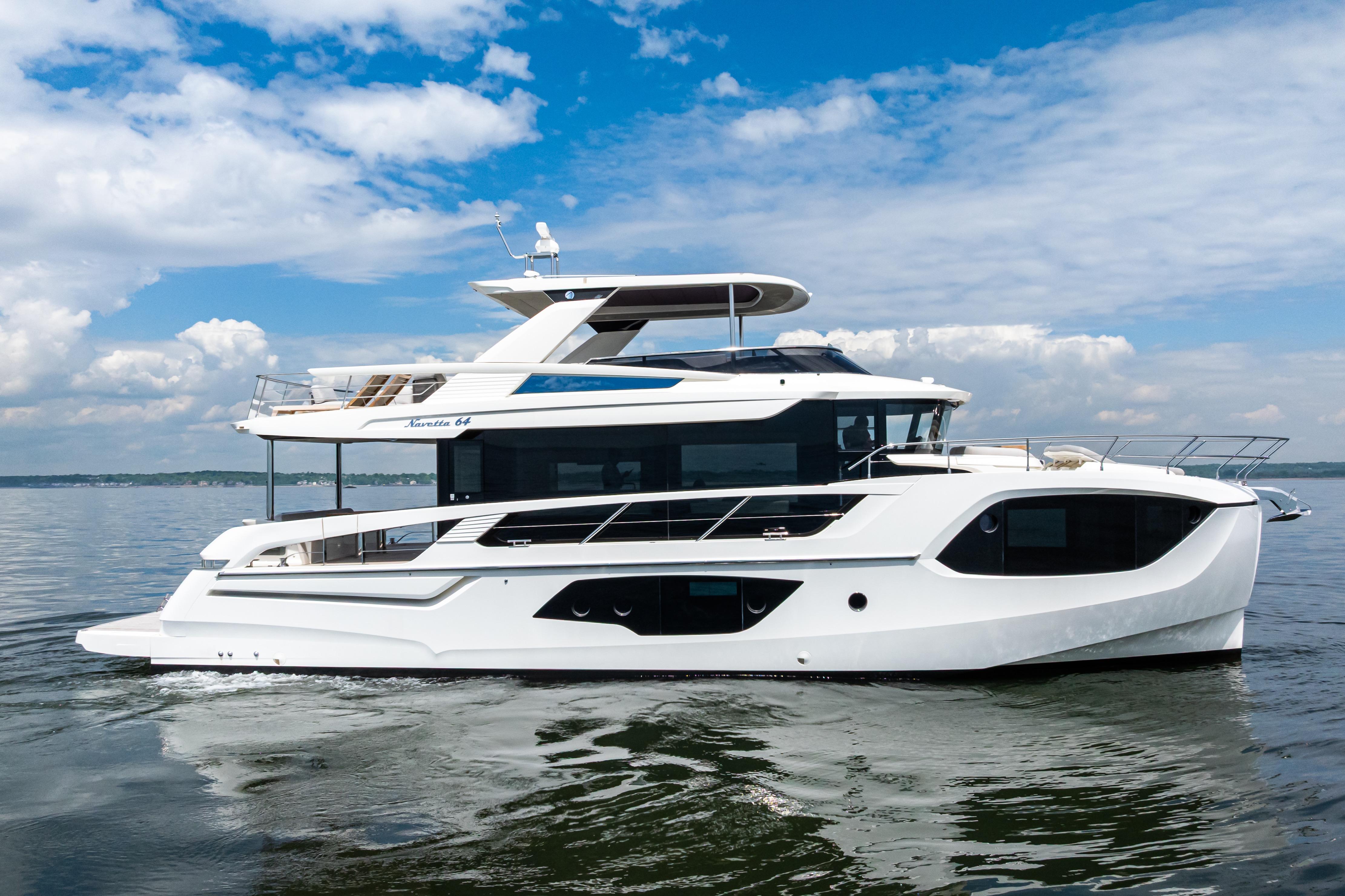 Luxury 2022 Absolute 64 Navetta yacht cruising on calm waters under a blue sky.