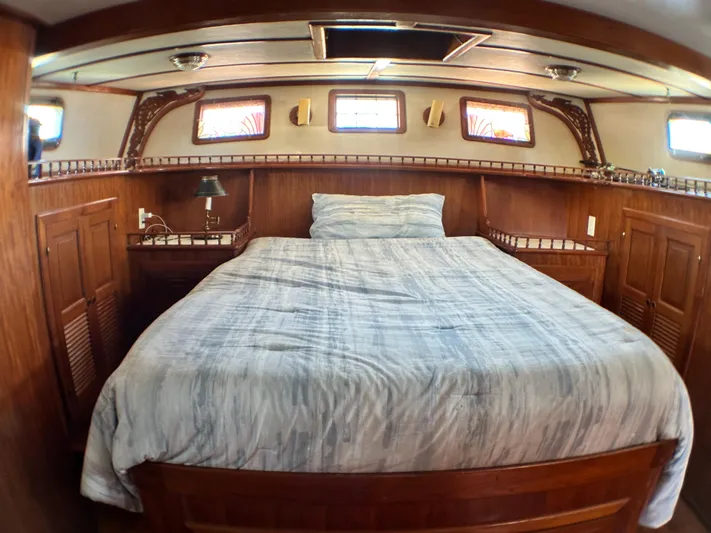 Whiskey River Yacht Photos Pics Cozy cabin interior of 1981 Island Trader 46 with wooden furnishings and a comfortable bed.