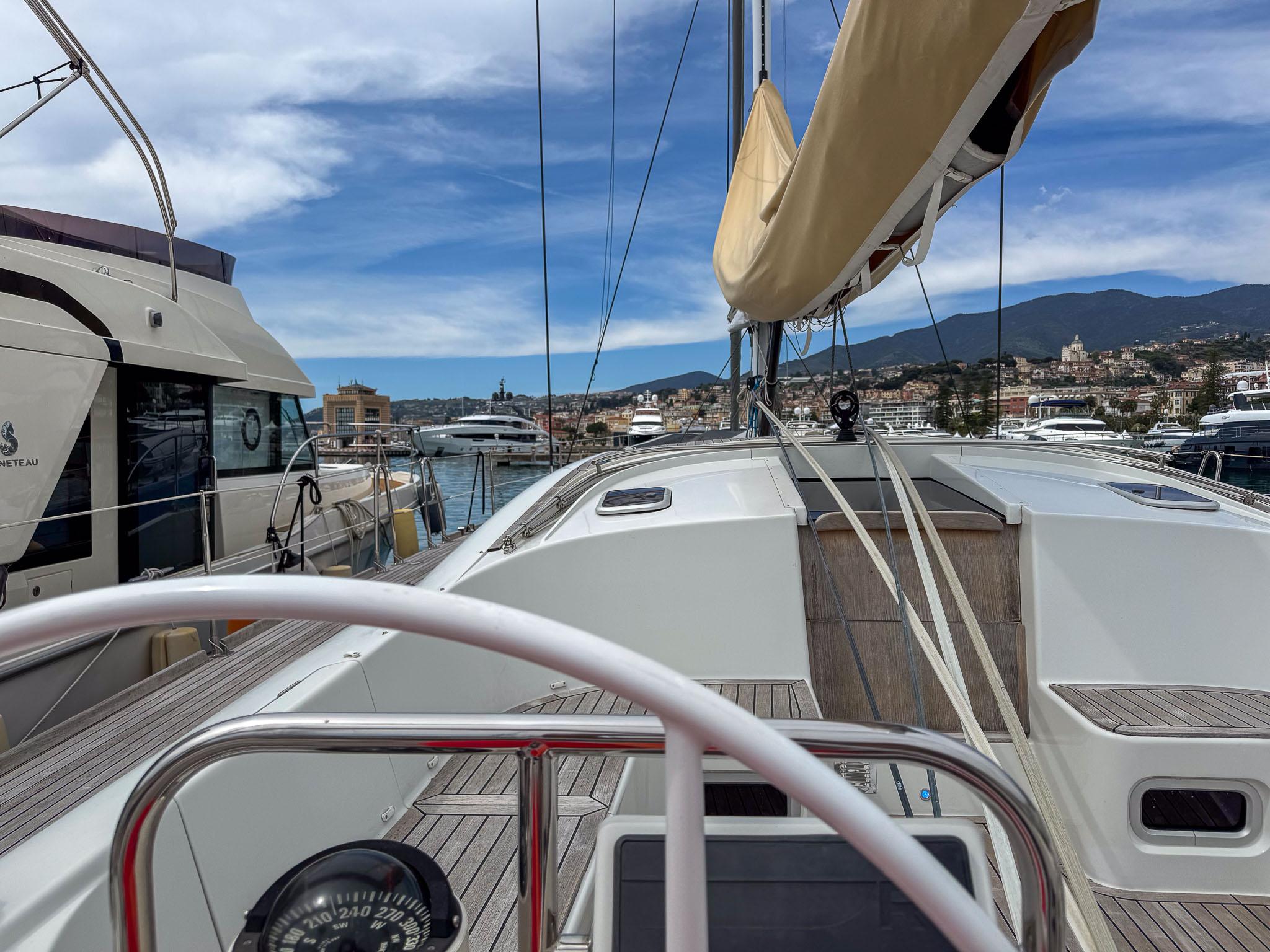 Sailing yacht Comar Comet 62 RS, 2020 model, docked in a marina with scenic mountain views.
