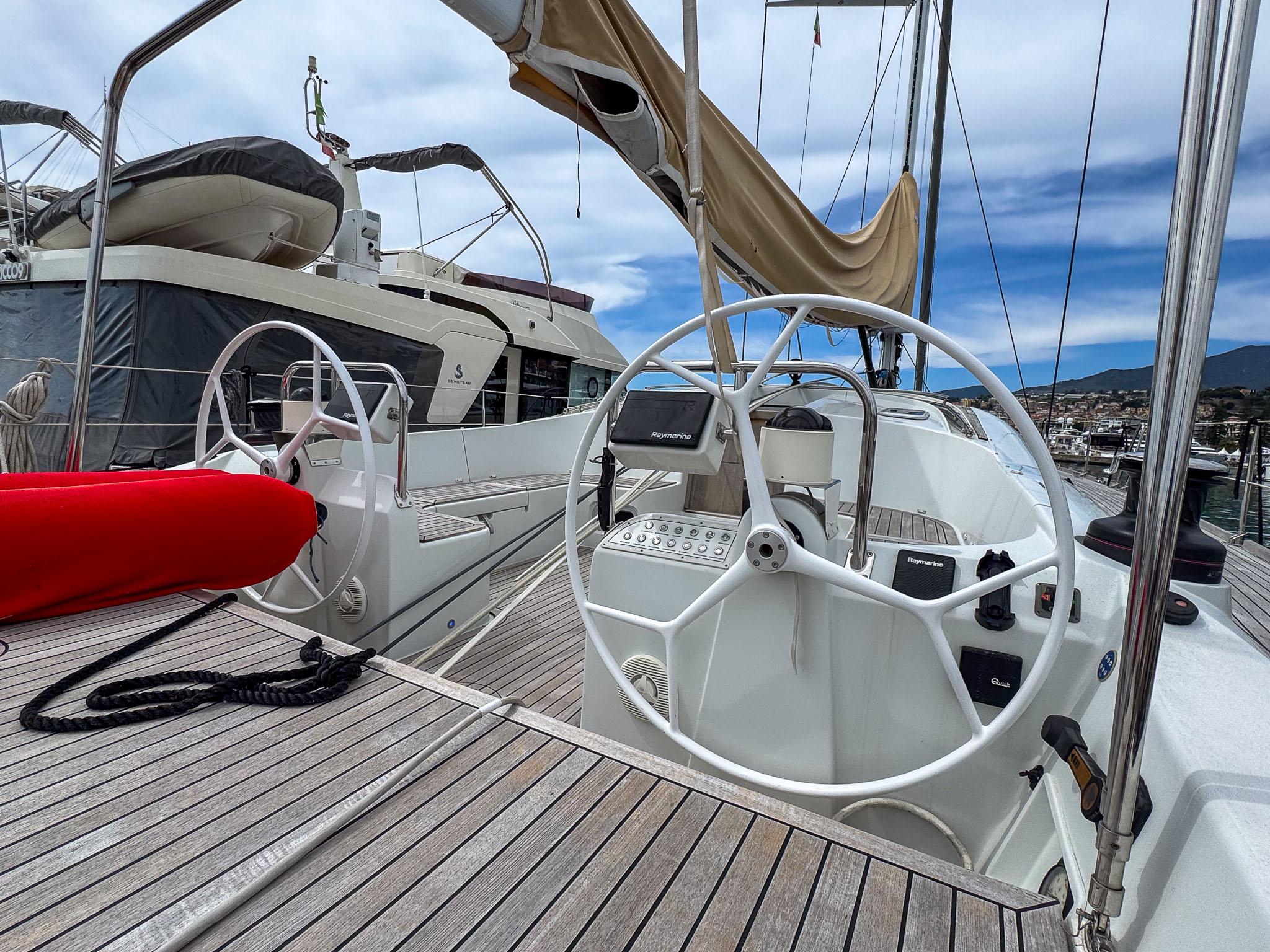 2020 Comar Comet 62 RS yacht deck with dual steering wheels and wooden flooring.