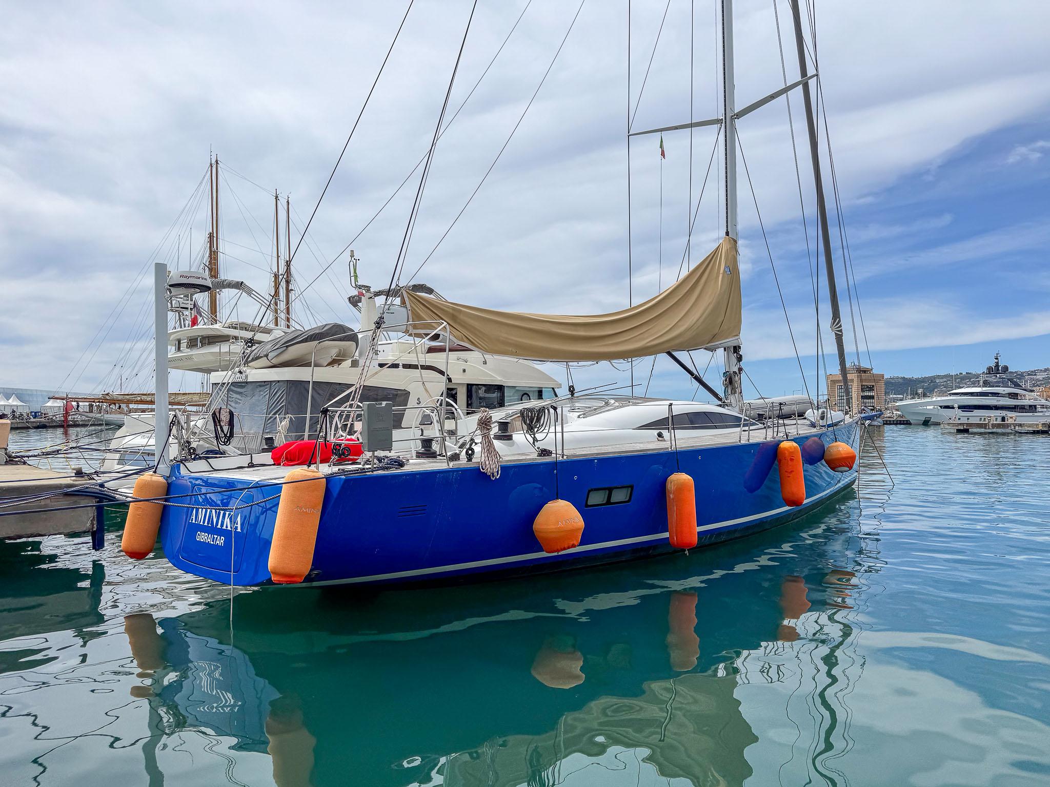 2020 Comar Comet 62 RS sailboat docked in marina with blue hull and orange fenders.