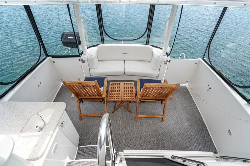 At Ease Yacht Photos Pics 2004 Silverton 39 Motor Yacht interior with seating and table, overlooking water.