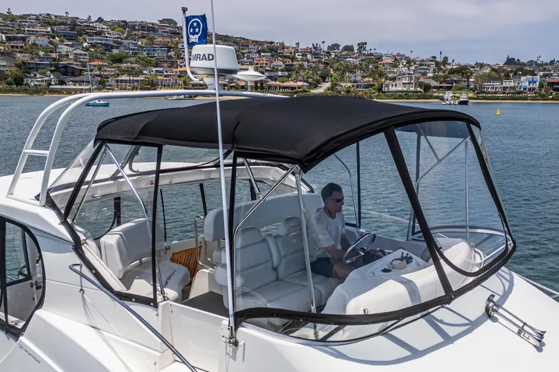 At Ease Yacht Photos Pics 2004 Silverton 39 Motor Yacht cruising on a scenic waterway with hillside homes in the background.