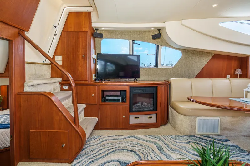 At Ease Yacht Photos Pics Luxurious interior of 2004 Silverton 39 Motor Yacht with TV, seating, and elegant wood finishes.
