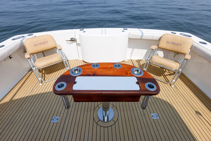 No Whey Yacht Photos Pics 2023 Henriques 42 Express Hardtop boat deck with chairs and table, ocean view.