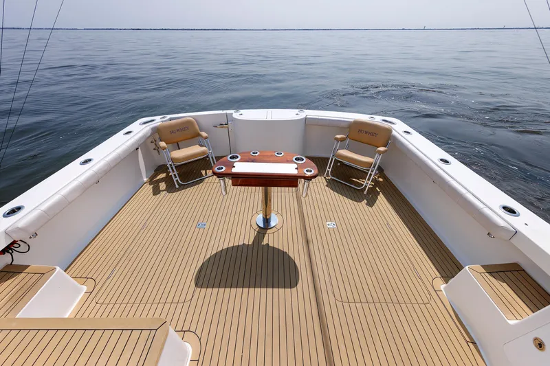 No Whey Yacht Photos Pics 2023 Henriques 42 Express Hardtop boat deck with chairs and table on calm water.