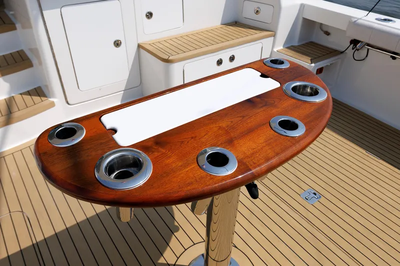 No Whey Yacht Photos Pics Henriques 42 Express Hardtop 2023 boat deck with wooden table and cup holders.