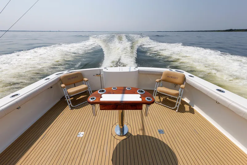 No Whey Yacht Photos Pics 2023 Henriques 42 Express Hardtop boat deck with chairs and table on open water.