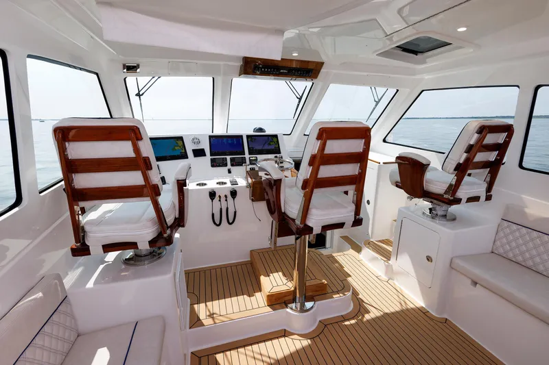 No Whey Yacht Photos Pics 2023 Henriques 42 Express Hardtop interior with helm, wooden seats, and navigation equipment.