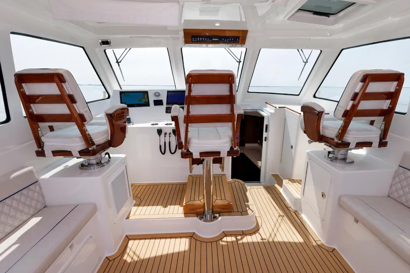 No Whey Yacht Photos Pics 2023 Henriques 42 Express Hardtop interior with helm chairs and navigation equipment.