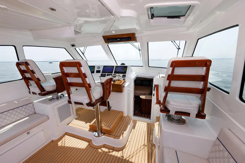 No Whey Yacht Photos Pics Interior of 2023 Henriques 42 Express Hardtop boat with wooden seating and navigation controls.