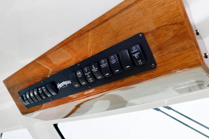 No Whey Yacht Photos Pics Control panel of 2023 Henriques 42 Express Hardtop with wooden finish and labeled switches.