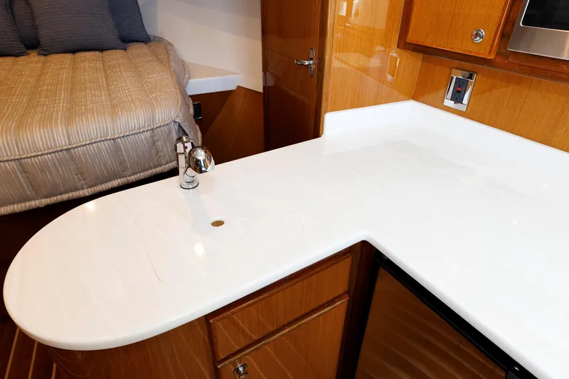 No Whey Yacht Photos Pics 2023 Henriques 42 Express Hardtop interior with sleek kitchenette and cozy sleeping area.