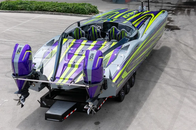  Yacht Photos Pics 2024 MTI 440X powerboat with vibrant purple and green design on a trailer.