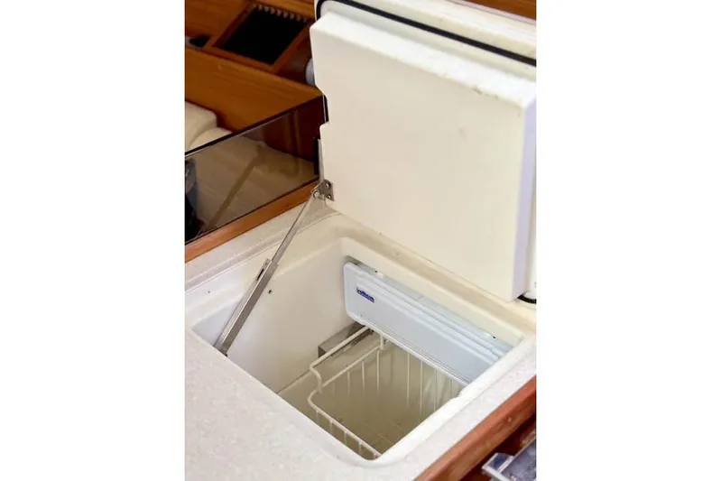 Falken Yacht Photos Pics Open refrigerator in 2017 Catalina model boat interior, showcasing storage space.