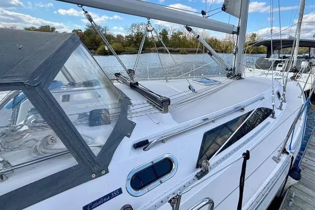 Falken Yacht Photos Pics 2017 Catalina sailboat docked by a serene lake under a blue sky.