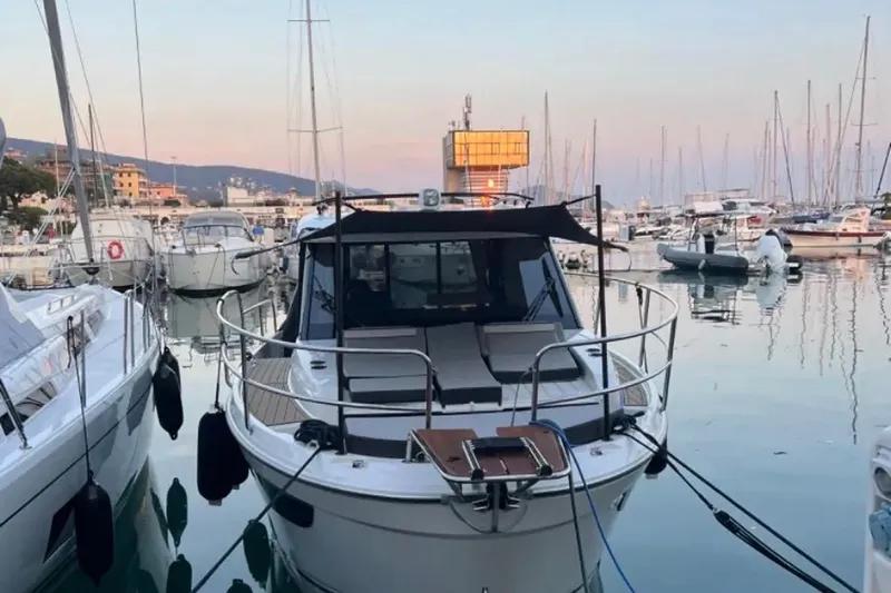  Yacht Photos Pics 2024 Jeanneau Merry Fisher 895 docked in a serene marina at sunset.