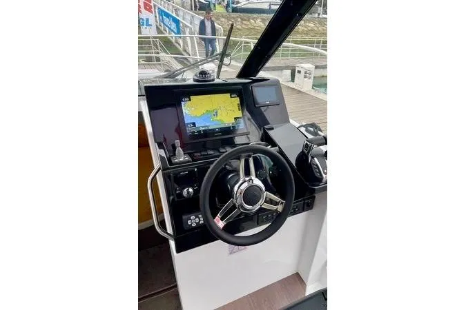  Yacht Photos Pics 2024 Jeanneau Merry Fisher 895 helm with navigation display and steering wheel.