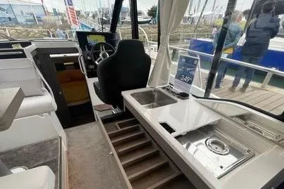  Yacht Photos Pics 2024 Jeanneau Merry Fisher 895 interior with helm, sink, and seating area.