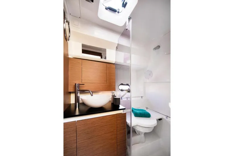Sabinal Yacht Photos Pics Manufacturer Provided Image: Modern bathroom in 2019 Jeanneau Leader 10.5 boat with wooden cabinets and white fixtures.