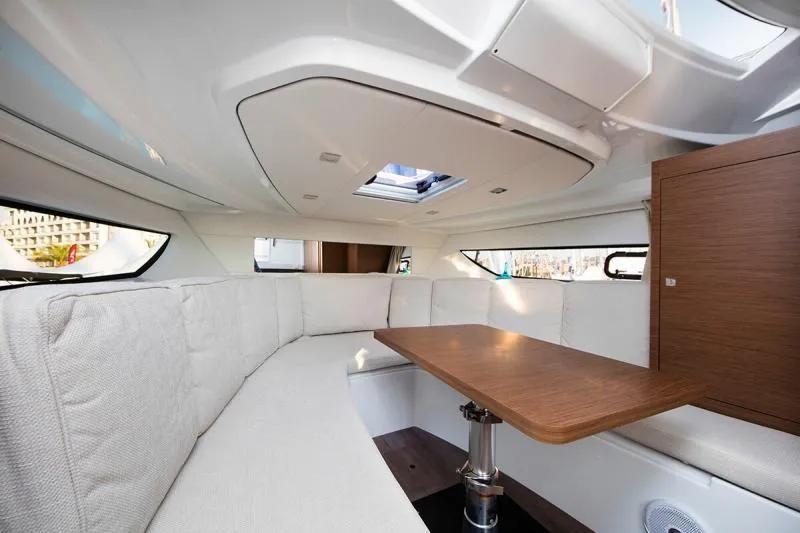Sabinal Yacht Photos Pics Manufacturer Provided Image: Interior of 2019 Jeanneau Leader 10.5 with white seating and wooden table.