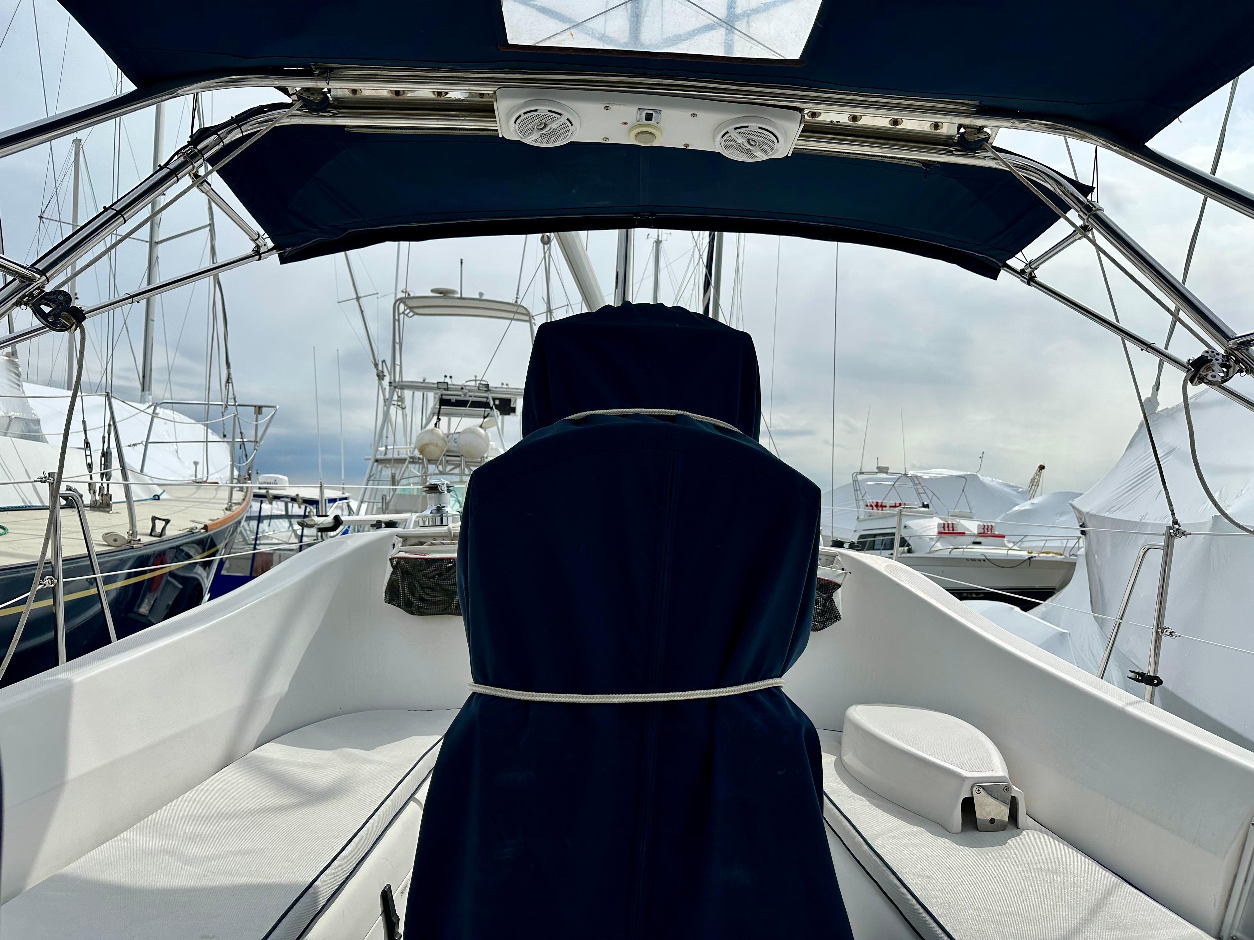 2006 Hunter 31 sailboat cockpit with blue canopy and marina view.