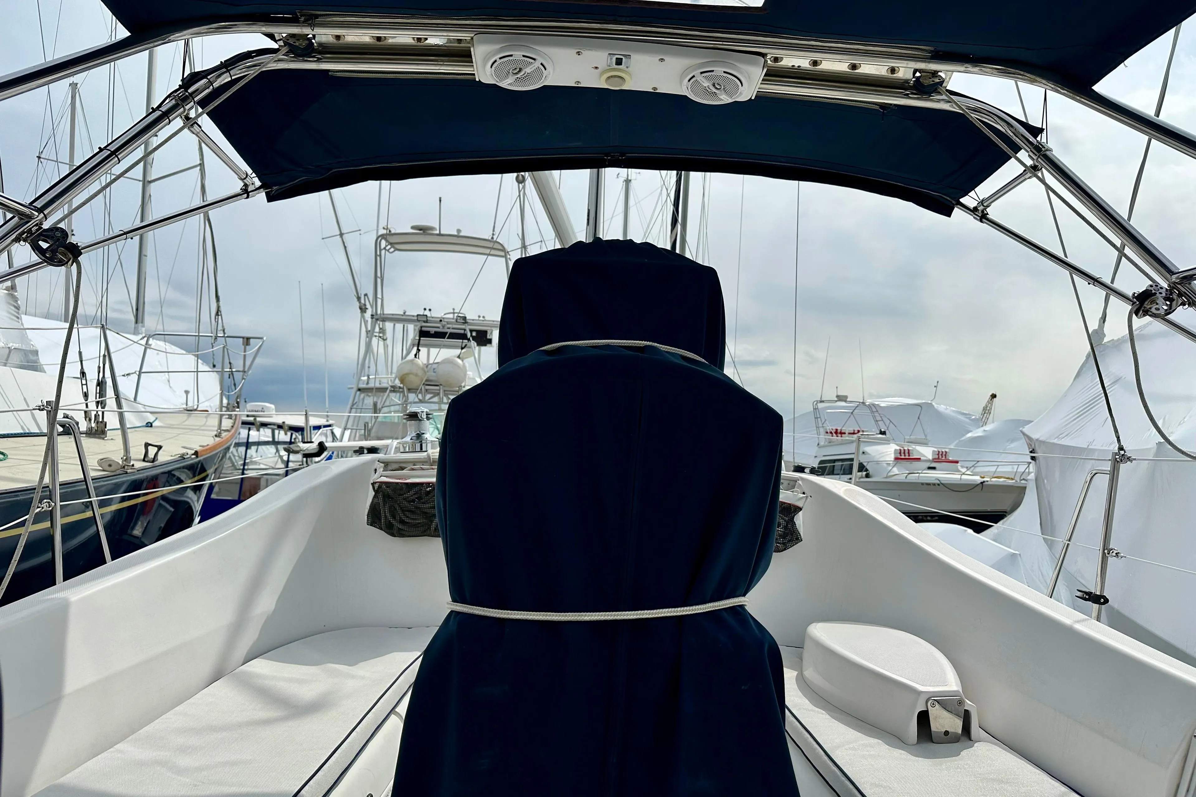 2006 Hunter 31 sailboat cockpit with blue canopy and marina view.