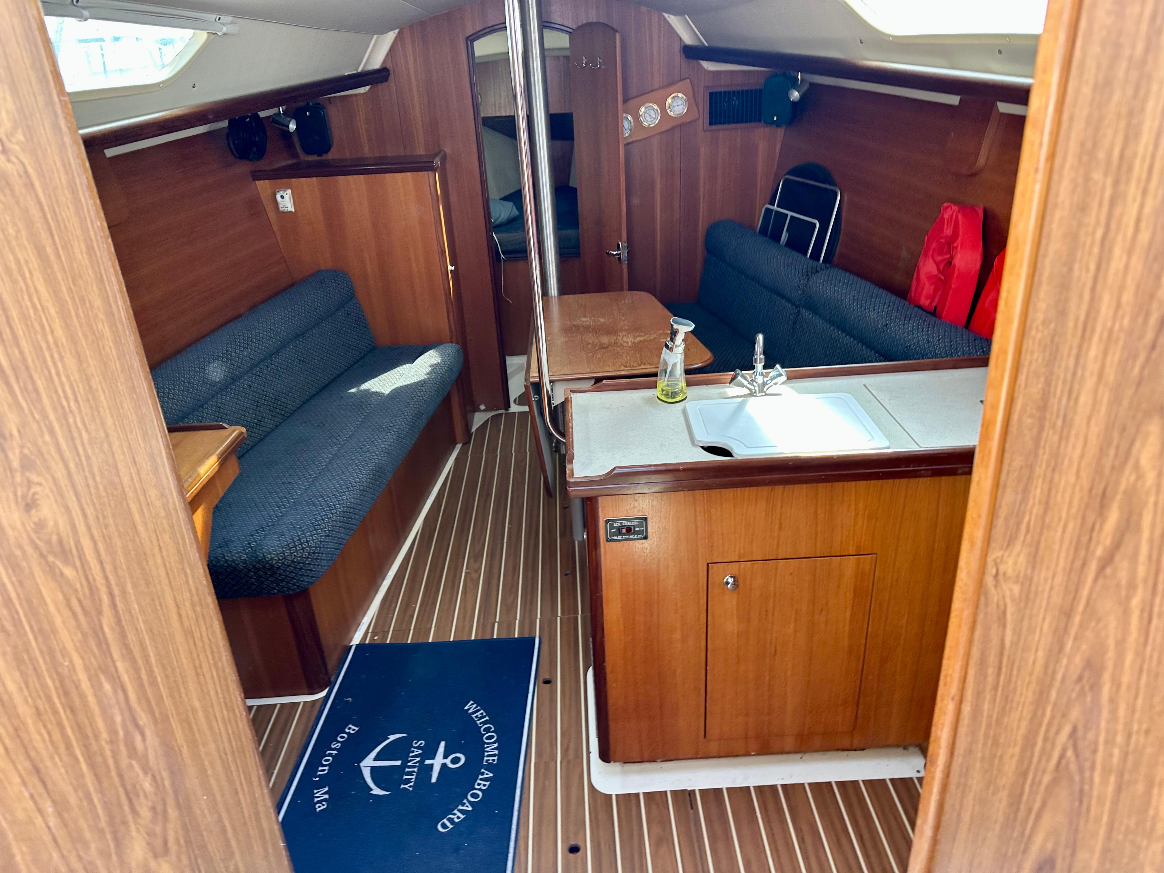 Interior of a 2006 Hunter 31 sailboat with wood finish and seating area.