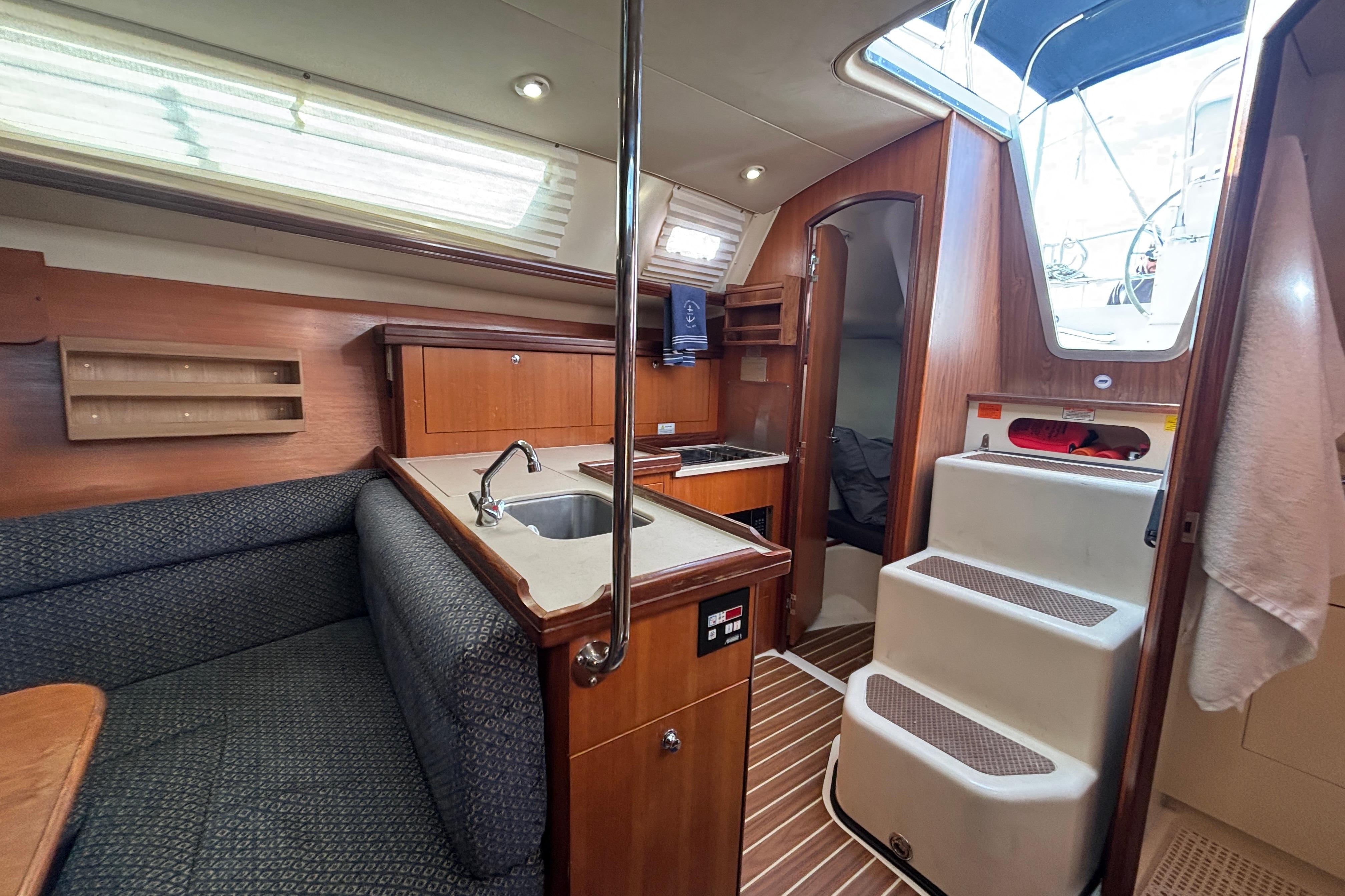 Interior of 2006 Hunter 31 sailboat with kitchen and seating area.