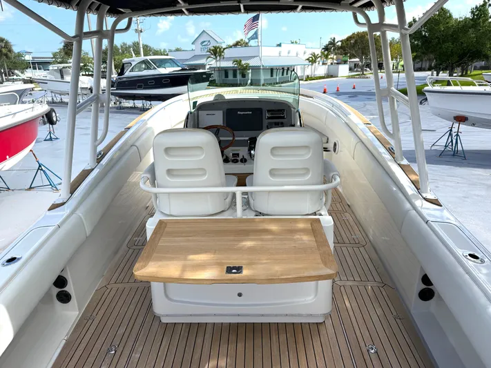 Stop Talking Yacht Photos Pics 2014 Chris-Craft Catalina 29 boat interior with dual seats and wooden deck.