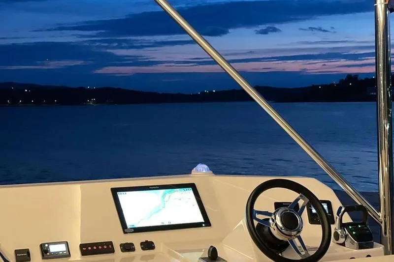  Yacht Photos Pics 2023 Leopard 53 Powercat helm with navigation screen at sunset on the water.