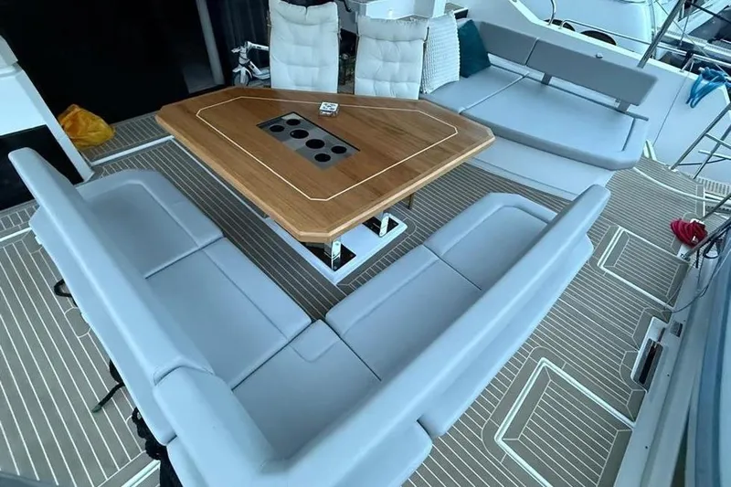  Yacht Photos Pics Luxurious seating area on 2023 Leopard 53 Powercat yacht with elegant wooden table.
