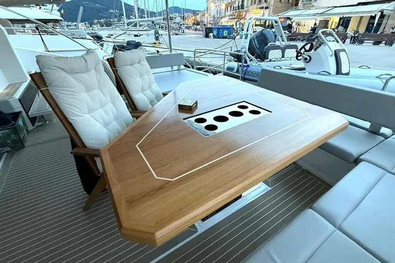  Yacht Photos Pics Luxurious deck seating on 2023 Leopard 53 Powercat yacht with wooden table and cushioned chairs.