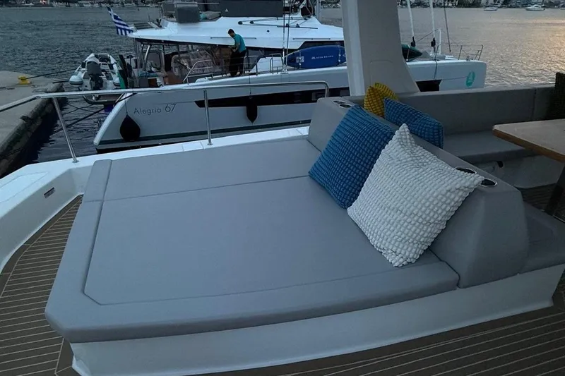  Yacht Photos Pics 2023 Leopard 53 Powercat yacht with cushioned seating and colorful pillows at sunset.
