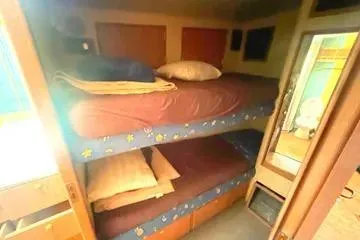 Cyclone Yacht Photos Pics Bunk beds in 1996 Buddy Davis 67 yacht cabin, featuring cozy bedding and wooden accents.