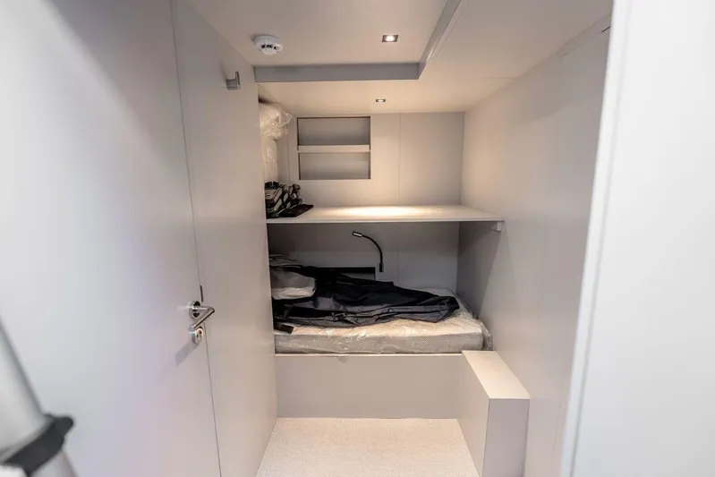 Aspen And Delilah Yacht Photos Pics Interior cabin of 2023 Tecnomar 63 Lamborghini yacht, featuring minimalist design and compact sleeping area.