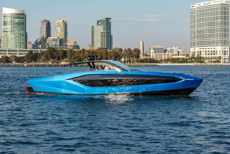 Aspen And Delilah Yacht Photos Pics 2023 Tecnomar 63 Lamborghini yacht cruising near city skyline.